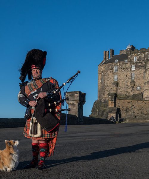 Tocador de gaita de foles em frente ao Castelo de Edimburgo, Escócia