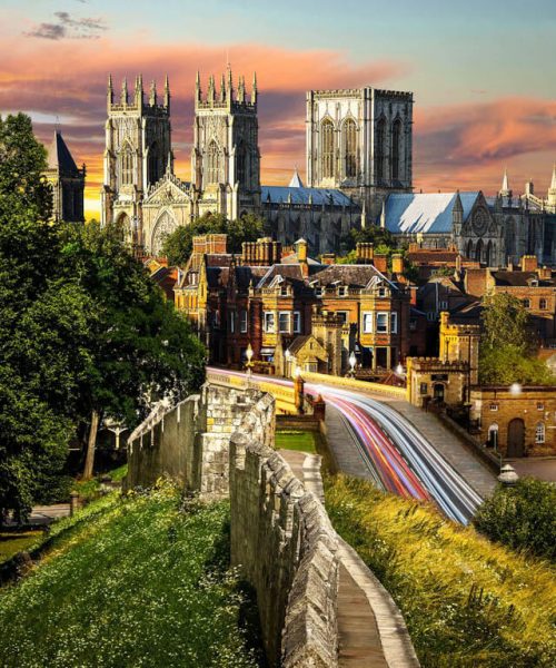 Vista panorâmica do centro histórico de York ao entardecer, com muralhas medievais e construções típicas